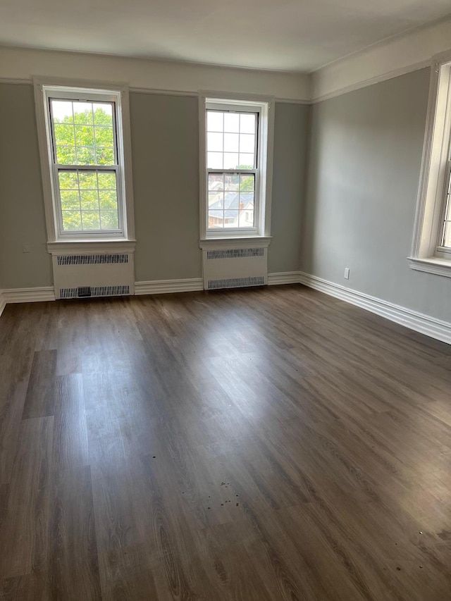 88-11 Elmhurst Ave Unit D15, Elmhurst, NY 11373 - spare room with radiator heating unit, dark wood-style floors, and plenty of natural light