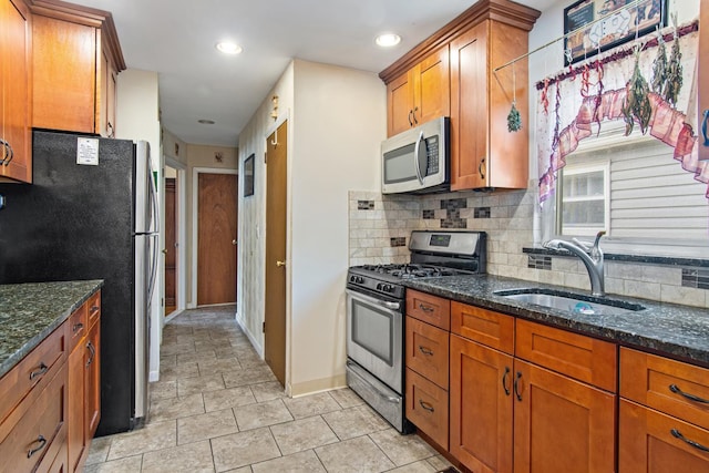 2088 Virgil Pl, Bronx, NY 10473 - kitchen with appliances with stainless steel finishes, brown cabinetry, decorative backsplash, dark stone countertops, and recessed lighting