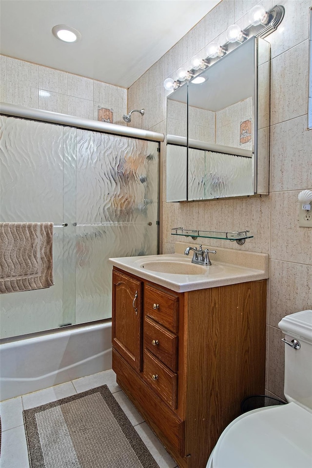 2088 Virgil Pl, Bronx, NY 10473 - bathroom with combined bath / shower with glass door, vanity, tile patterned floors, and tile walls