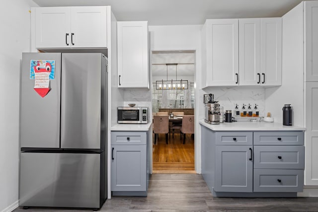 17 Sachem St, East Rockaway, NY 11518 - kitchen featuring appliances with stainless steel finishes, dark wood-style flooring, decorative backsplash, and gray cabinetry