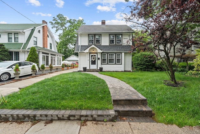 17 Sachem St, East Rockaway, NY 11518 - view of front of house with a chimney, a front yard, roof with shingles, and entry steps