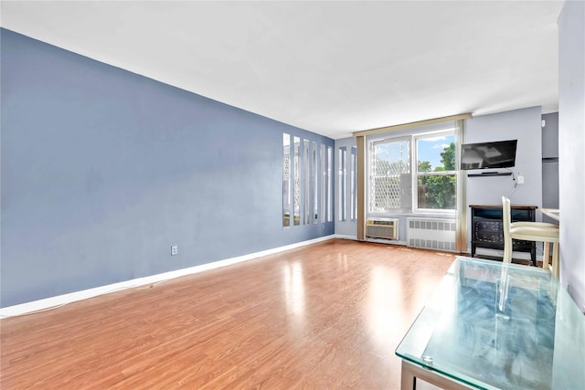68-15 Selfridge St Unit 5D, Forest Hills, NY 11375 - unfurnished living room with radiator and wood finished floors