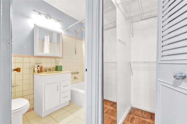 68-15 Selfridge St Unit 5D, Forest Hills, NY 11375 - bathroom with tile walls, vanity, bathtub / shower combination, wainscoting, and a walk in closet