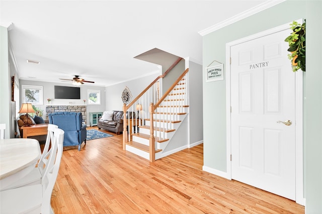 85 Jay St, Stony Point, NY 10980 - entryway with stairway, crown molding, a ceiling fan, light wood finished floors, and a stone fireplace
