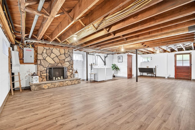 85 Jay St, Stony Point, NY 10980 - below grade area with washing machine and clothes dryer, electric panel, wood finished floors, and a stone fireplace