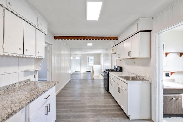 33 N Rte 303, Congers, NY 10920 - kitchen with black gas range oven, wood finished floors, white cabinets, and decorative backsplash
