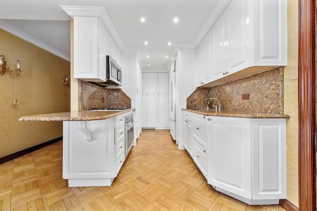11201 Queens Blvd Unit 10B, Forest Hills, NY 11375 - kitchen featuring appliances with stainless steel finishes, white cabinetry, light stone counters, recessed lighting, and ornamental molding