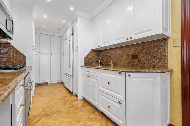 11201 Queens Blvd Unit 10B, Forest Hills, NY 11375 - kitchen featuring white cabinets, stainless steel appliances, backsplash, recessed lighting, and dark stone counters