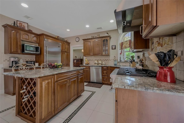 26 Sesame St, Kings Park, NY 11754 - kitchen featuring built in appliances, ventilation hood, light tile patterned floors, decorative backsplash, and light stone countertops