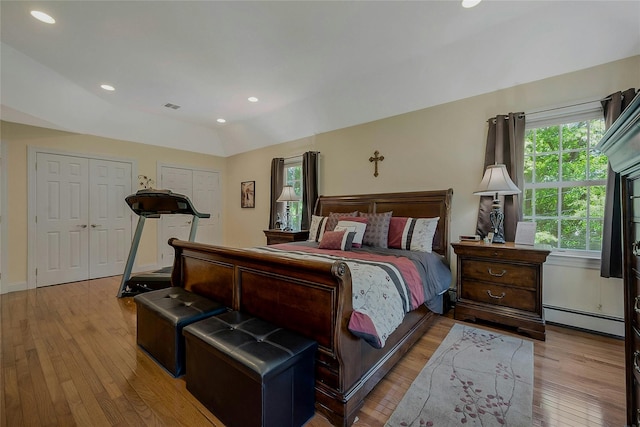 26 Sesame St, Kings Park, NY 11754 - bedroom with baseboard heating, hardwood / wood-style floors, two closets, vaulted ceiling, and recessed lighting