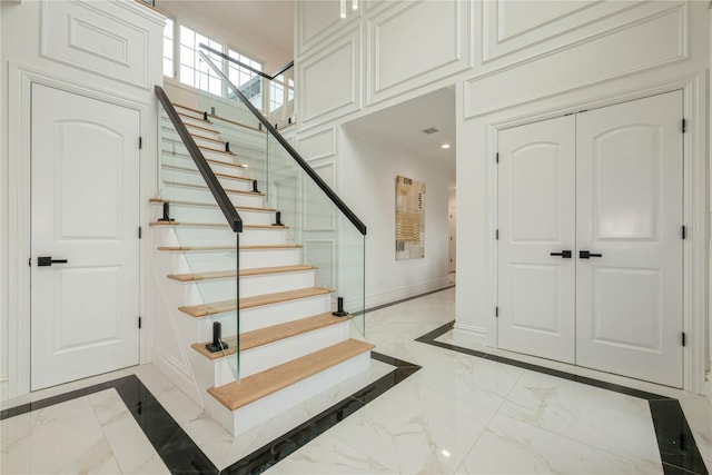 52 Cortland Ave, Hicksville, NY 11801 - stairway featuring marble tiled flooring, crown molding, inlaid floor details, and recessed lighting