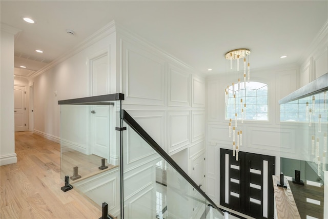 52 Cortland Ave, Hicksville, NY 11801 - stairway featuring wood finished floors, a chandelier, ornamental molding, recessed lighting, and a decorative wall