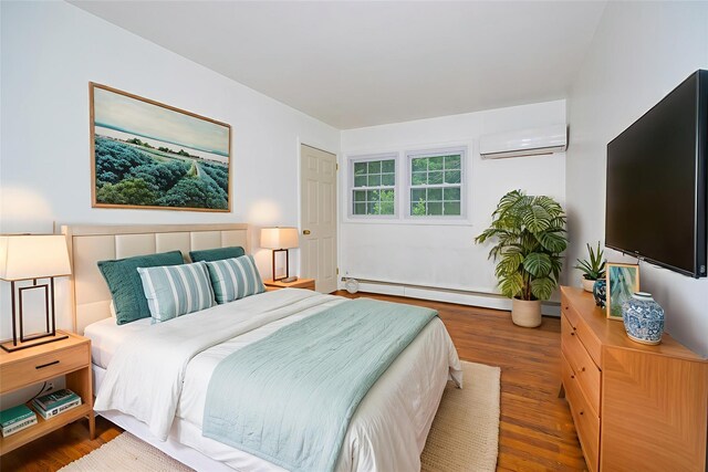 16 Bushwick Rd, Poughkeepsie, NY 12603 - bedroom with a baseboard radiator, a wall mounted AC, and wood finished floors