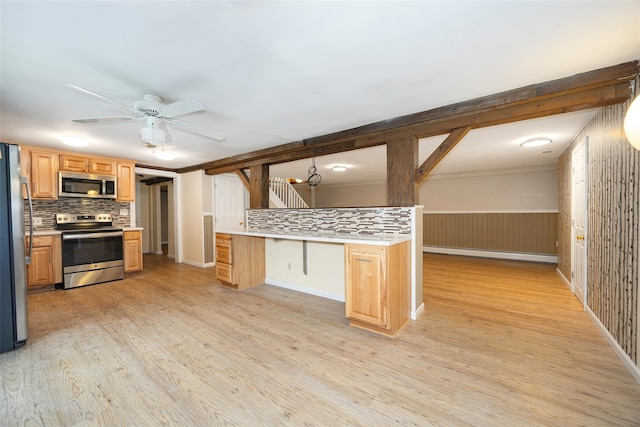 16 Bushwick Rd, Poughkeepsie, NY 12603 - kitchen featuring stainless steel appliances, decorative backsplash, light wood-type flooring, ceiling fan, and a wainscoted wall
