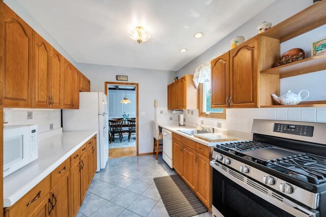 29 E St, Hicksville, NY 11801 - kitchen featuring white appliances, light countertops, tasteful backsplash, brown cabinetry, and light tile patterned floors