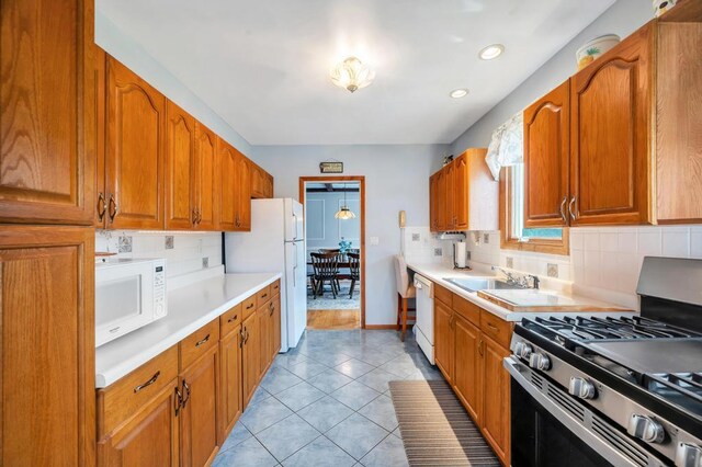 29 E St, Hicksville, NY 11801 - kitchen with white appliances, tasteful backsplash, brown cabinets, light countertops, and light tile patterned flooring