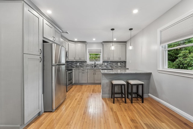 185 Carlton Dr E, Shirley, NY 11967 - kitchen featuring stainless steel appliances, gray cabinetry, decorative backsplash, light wood-style flooring, and a peninsula