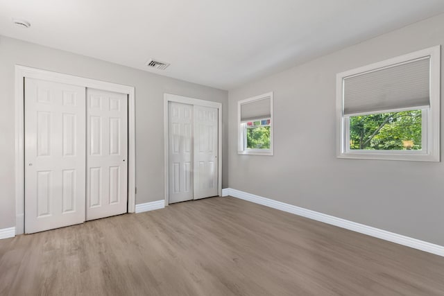 185 Carlton Dr E, Shirley, NY 11967 - unfurnished bedroom with two closets and light wood-type flooring