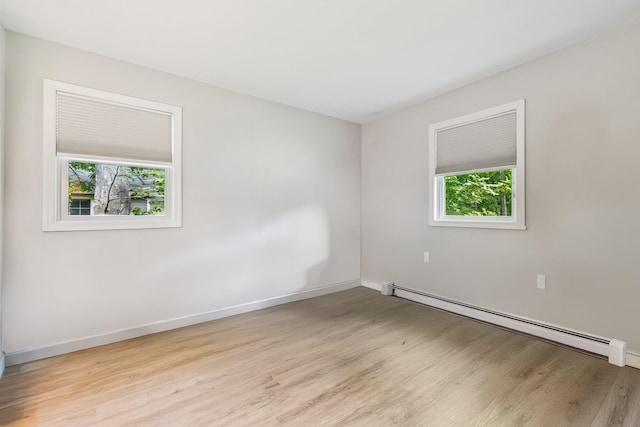 185 Carlton Dr E, Shirley, NY 11967 - spare room with a baseboard heating unit, wood finished floors, and healthy amount of natural light