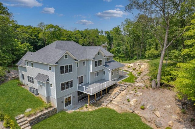 63 Buckout Rd, West Harrison, NY 10604 - rear view of property with a wooden deck, a lawn, and a wooded view