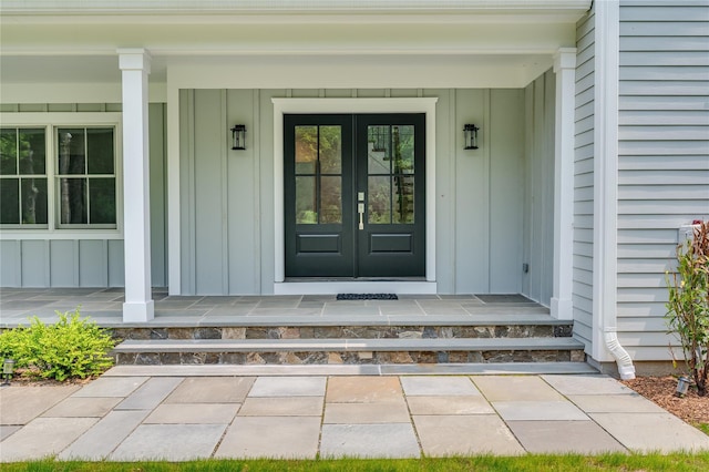 63 Buckout Rd, West Harrison, NY 10604 - doorway to property featuring board and batten siding, a porch, and french doors