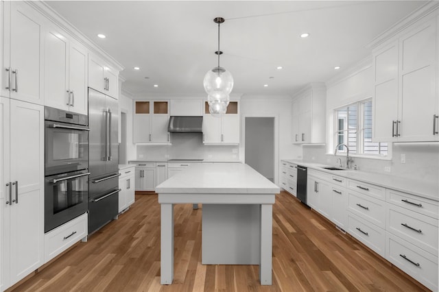 63 Buckout Rd, West Harrison, NY 10604 - kitchen featuring multiple ovens, high end fridge, backsplash, crown molding, and white cabinetry