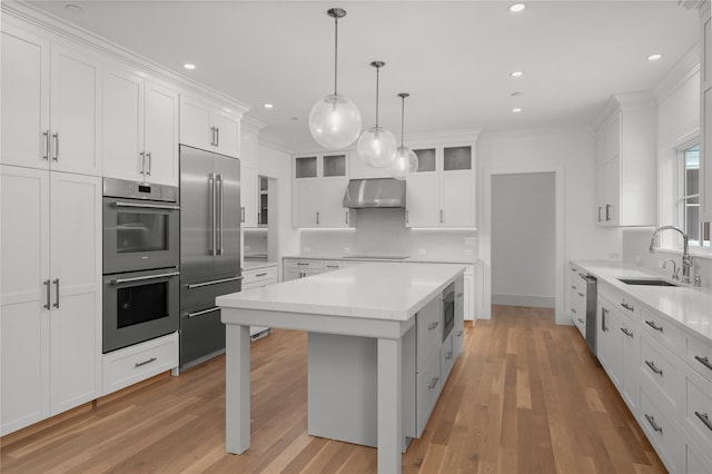 63 Buckout Rd, West Harrison, NY 10604 - kitchen featuring built in appliances, wall chimney range hood, light countertops, white cabinets, and recessed lighting