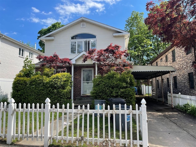24580 61st Ave Unit 68Th, Little Neck, NY 11362 - traditional home featuring a fenced front yard, brick siding, concrete driveway, and a detached carport