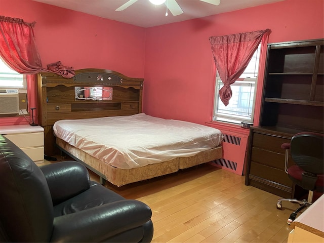 24580 61st Ave Unit 68Th, Little Neck, NY 11362 - bedroom with radiator, multiple windows, light wood finished floors, and a ceiling fan