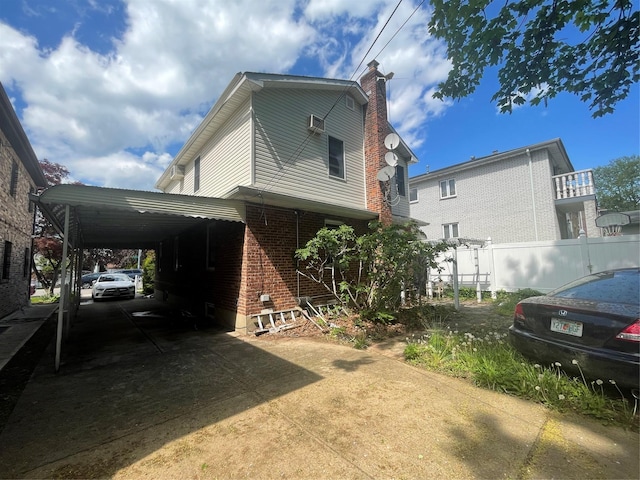24580 61st Ave Unit 68Th, Little Neck, NY 11362 - view of property exterior with driveway, brick siding, a chimney, and an attached carport