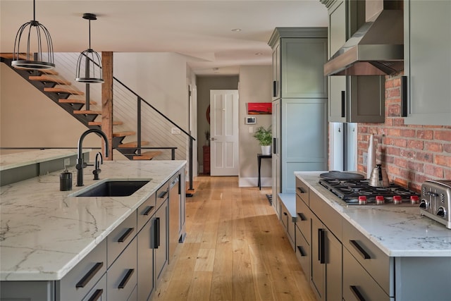 20 Paye Ave, Beacon, NY 12508 - kitchen with wall chimney exhaust hood, light wood-style flooring, stainless steel gas stovetop, pendant lighting, and light stone counters