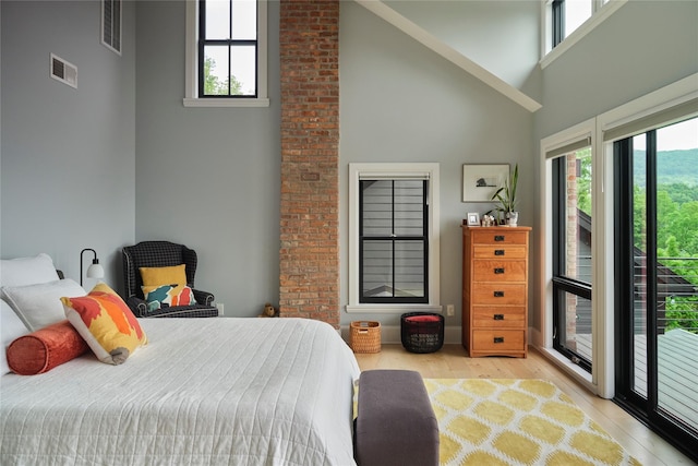 20 Paye Ave, Beacon, NY 12508 - bedroom with high vaulted ceiling, multiple windows, wood finished floors, and access to outside