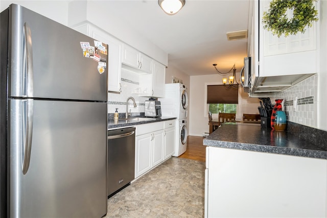1 Germonds Vlg Unit 16, Bardonia, NY 10954 - kitchen featuring appliances with stainless steel finishes, stacked washer / dryer, dark countertops, and decorative backsplash