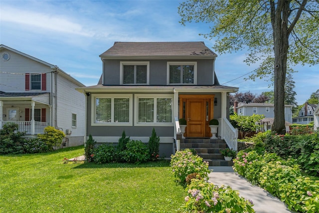 79 Fern St, New Rochelle, NY 10801 - view of front facade featuring a front lawn, a shingled roof, and stucco siding
