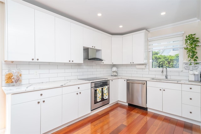 79 Fern St, New Rochelle, NY 10801 - kitchen with stainless steel appliances, decorative backsplash, light wood-style flooring, light stone countertops, and white cabinets