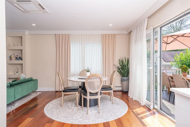 79 Fern St, New Rochelle, NY 10801 - dining room with crown molding, wood finished floors, a baseboard radiator, built in shelves, and recessed lighting