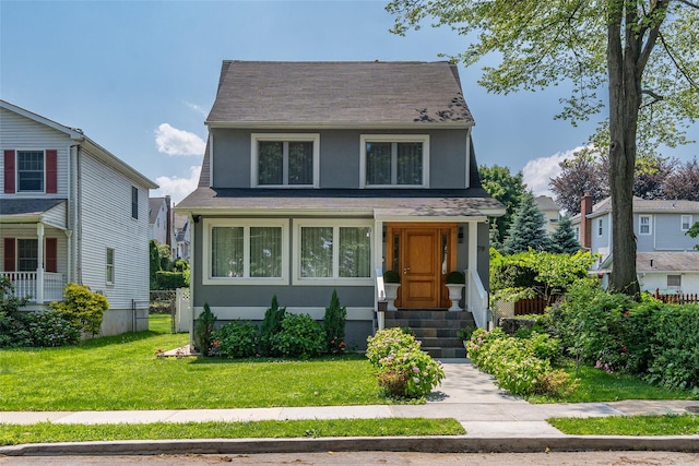 79 Fern St, New Rochelle, NY 10801 - view of front of house with entry steps, a front lawn, a shingled roof, and stucco siding