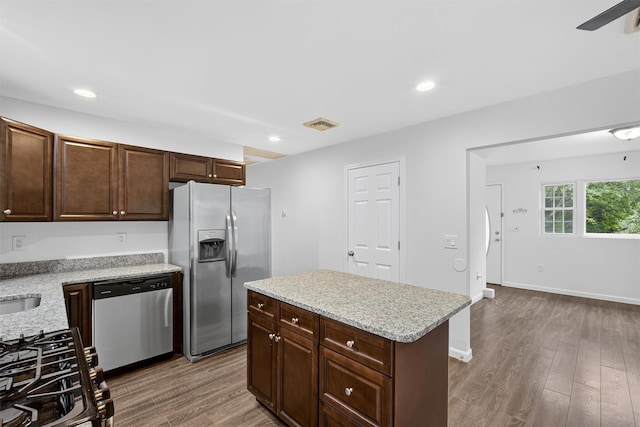 7 Jorge Ln, Wallkill, NY 12589 - kitchen featuring appliances with stainless steel finishes, wood finished floors, dark brown cabinets, recessed lighting, and light stone countertops