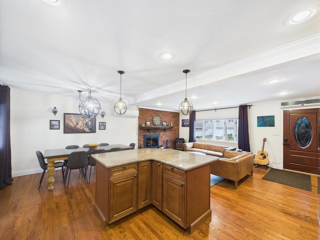 260 9th St, Bethpage, NY 11714 - kitchen featuring a fireplace, open floor plan, wood finished floors, crown molding, and recessed lighting