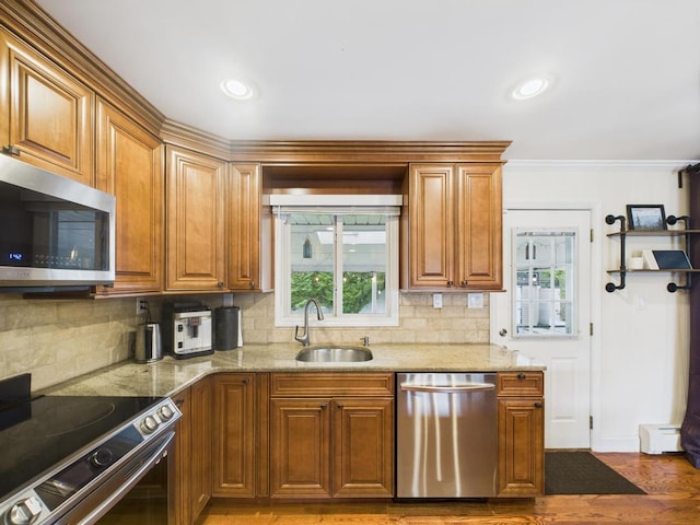 260 9th St, Bethpage, NY 11714 - kitchen with stainless steel appliances, tasteful backsplash, light wood-style flooring, brown cabinetry, and crown molding