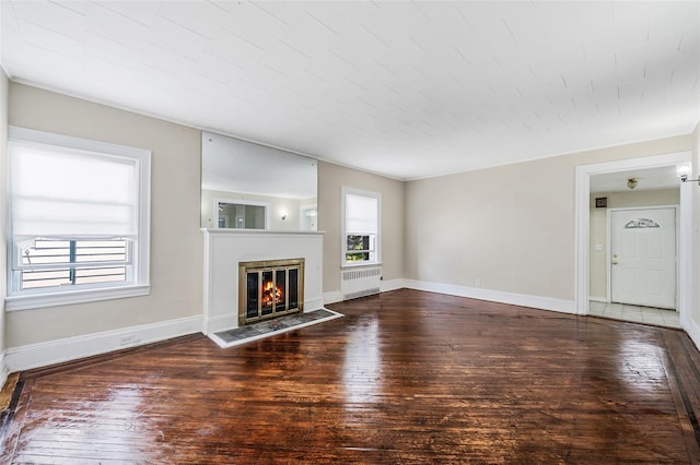 10 Leach St, Lynbrook, NY 11563 - unfurnished living room with radiator, hardwood / wood-style flooring, and a glass covered fireplace