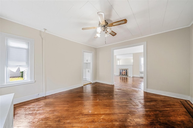 10 Leach St, Lynbrook, NY 11563 - spare room featuring hardwood / wood-style floors, a ceiling fan, crown molding, a glass covered fireplace, and radiator
