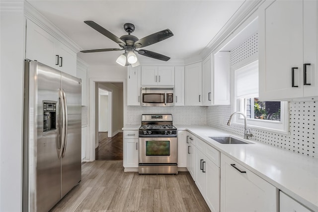10 Leach St, Lynbrook, NY 11563 - kitchen with appliances with stainless steel finishes, light countertops, white cabinets, light wood-type flooring, and decorative backsplash