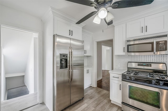 10 Leach St, Lynbrook, NY 11563 - kitchen featuring appliances with stainless steel finishes, white cabinets, light countertops, a ceiling fan, and decorative backsplash