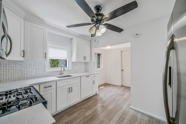 10 Leach St, Lynbrook, NY 11563 - kitchen with paneled dishwasher, decorative backsplash, white cabinets, light wood finished floors, and a ceiling fan