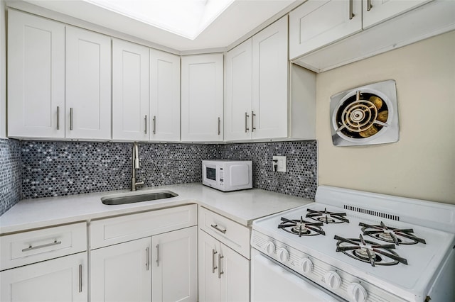 10 Leach St, Lynbrook, NY 11563 - kitchen featuring white appliances, light countertops, white cabinets, and backsplash
