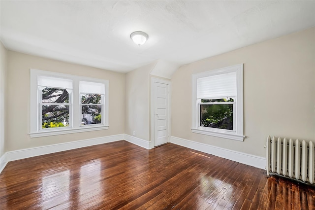 10 Leach St, Lynbrook, NY 11563 - spare room with radiator heating unit, plenty of natural light, and dark wood-style floors