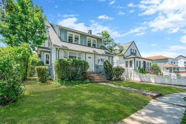 10 Leach St, Lynbrook, NY 11563 - view of front of house featuring a chimney, a shingled roof, and a residential view