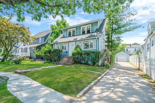 10 Leach St, Lynbrook, NY 11563 - view of front facade with asphalt driveway, an outdoor structure, a garage, and roof with shingles
