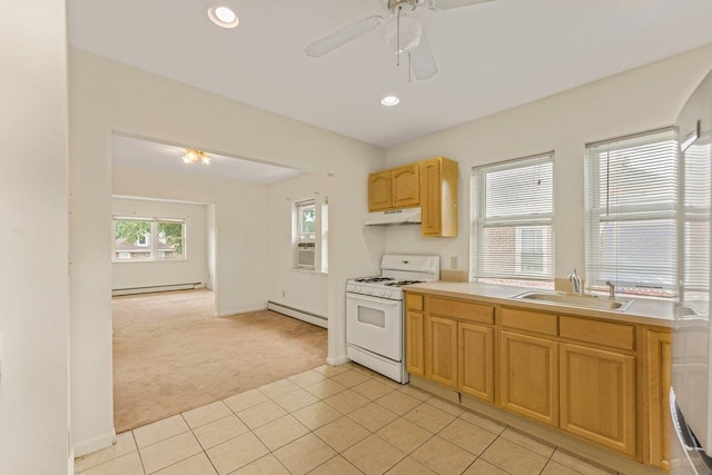 22 King Ave, Yonkers, NY 10704 - kitchen with white gas stove, light carpet, under cabinet range hood, a baseboard radiator, and a baseboard heating unit